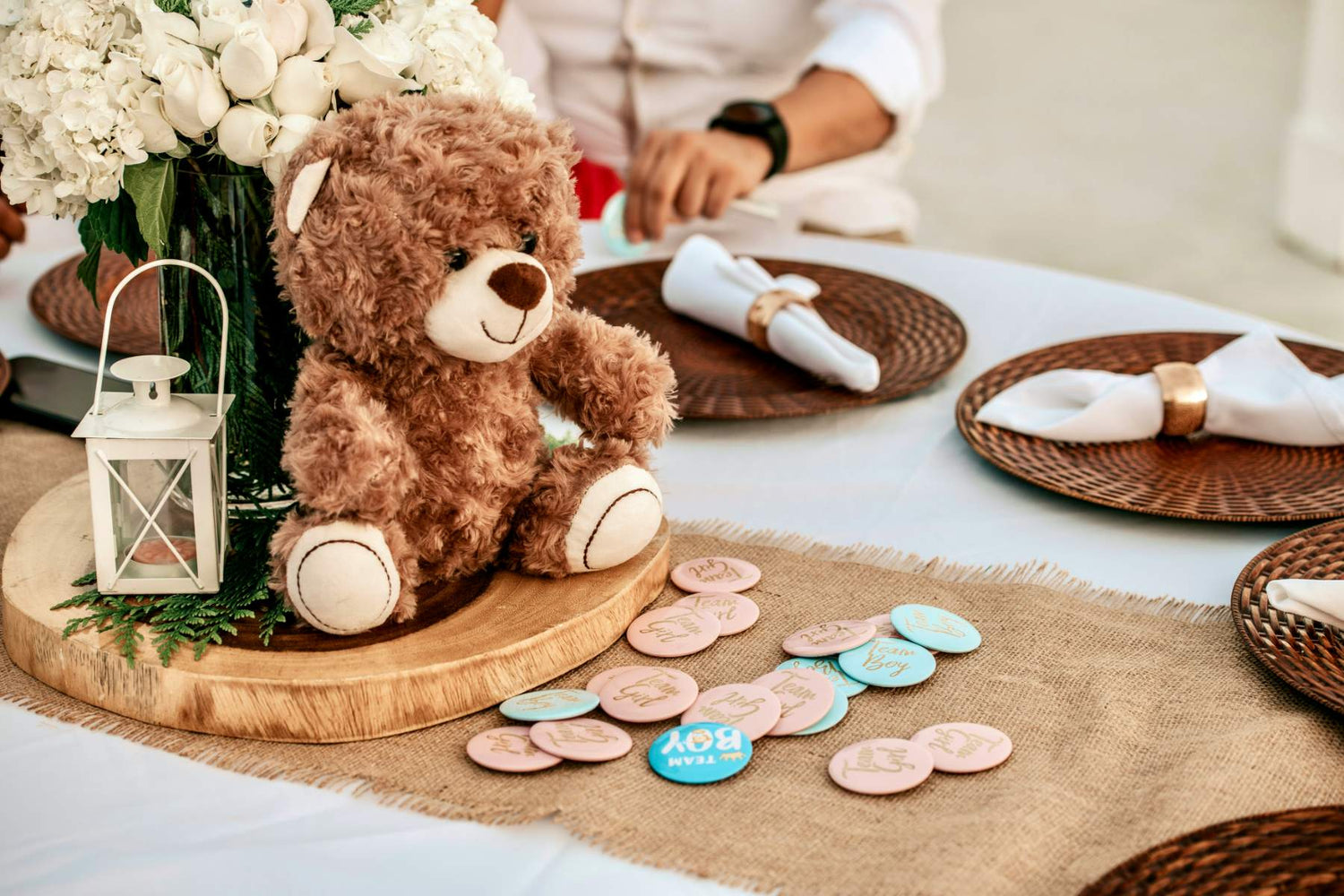 Plush bear gift sitting at a baby shower table with boy and girl decor.