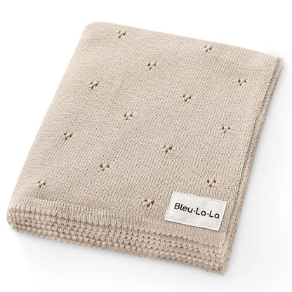 Beige knitted blanket with small star patterns and 'Bleu La La' label on a white background