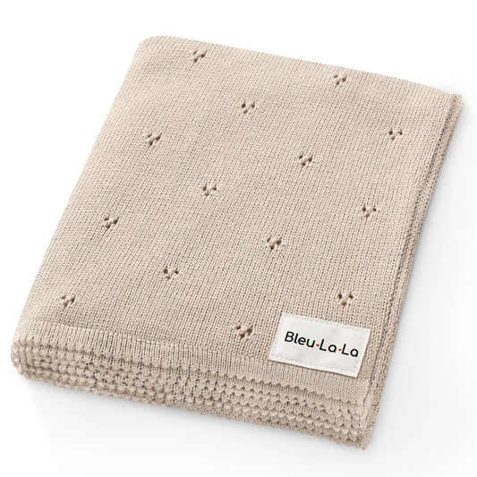 Beige knitted blanket with small star patterns and 'Bleu La La' label on a white background