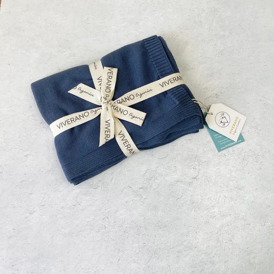 Folded navy blue blanket with 'Viverano' branding on a light gray background